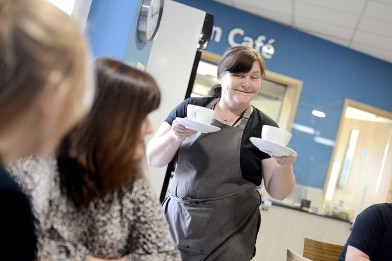 The on-site cafe at Newark Beacon. Two people are being served hot drinks.