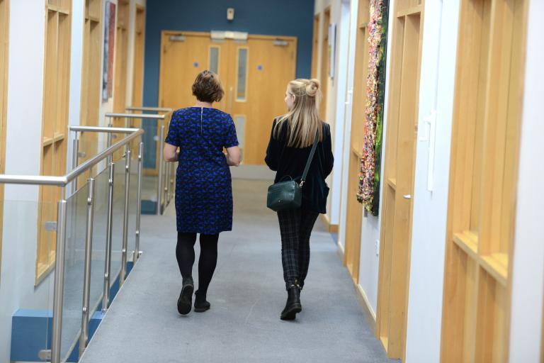 Two colleagues walking through a corridor in a Newark Beacon office.
