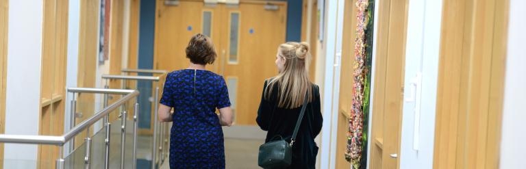 Two colleagues walking through a corridor in a Newark Beacon office.
